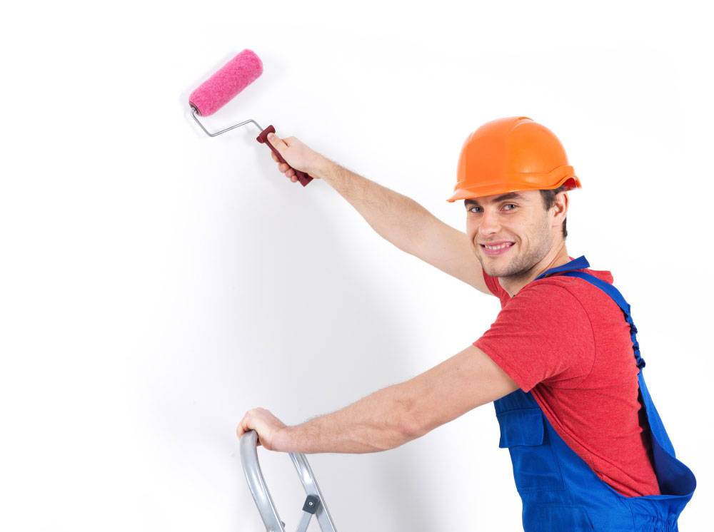 Realizzazione di opere in cartongesso a Treviso - imbianchino che sta lavorando su un muro bianco